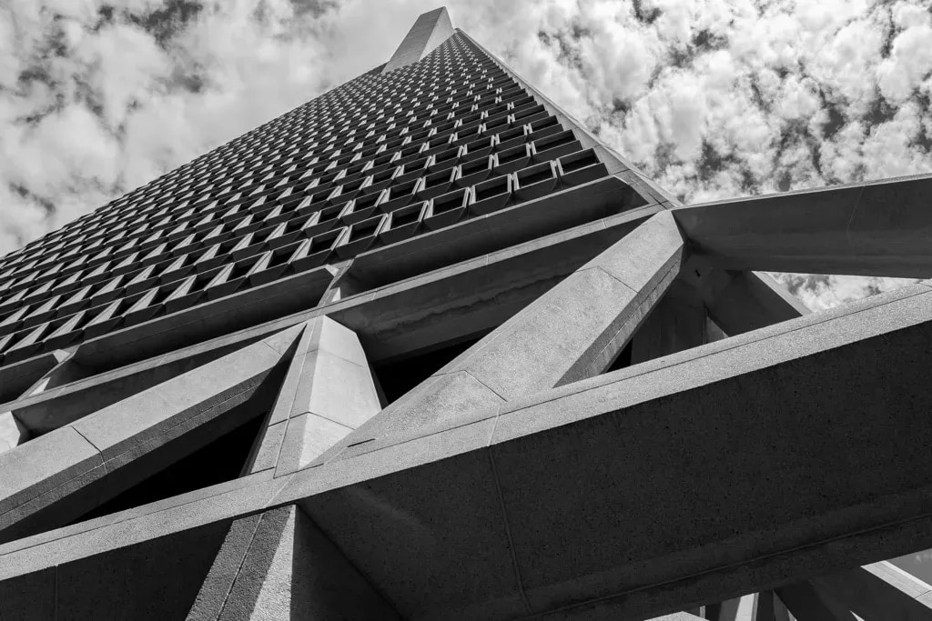 Upward view of the Transamerica Pyramid's geometric facade against wispy clouds, San Francisco