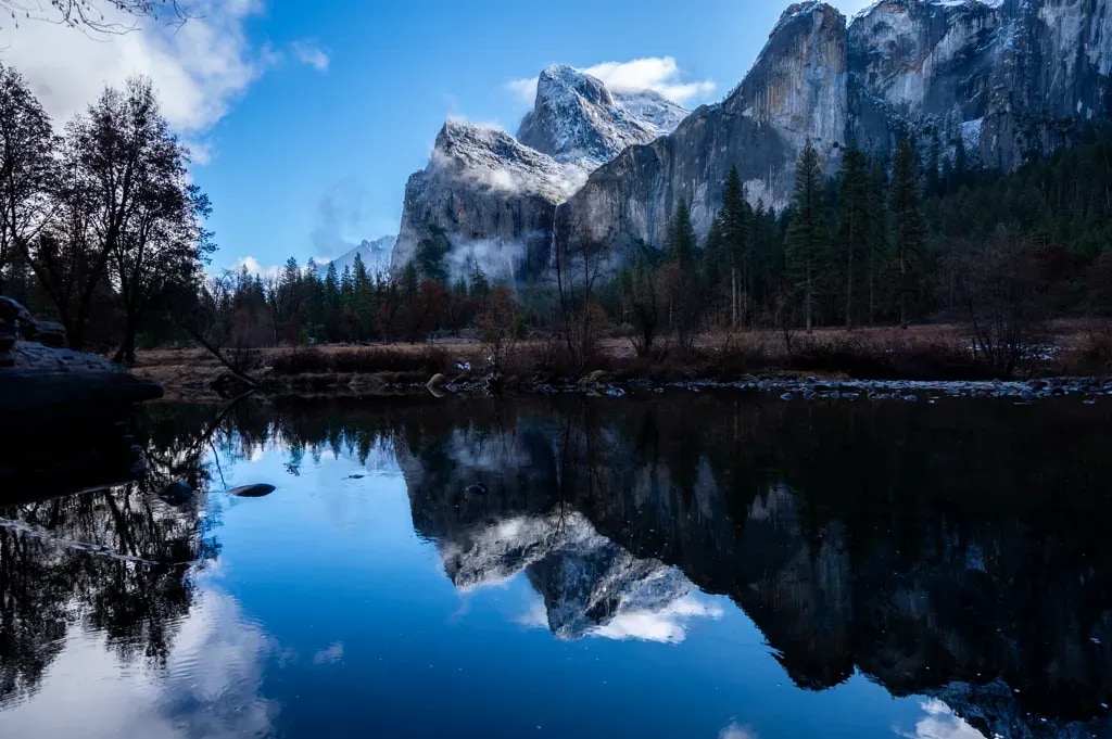 Cathedral Rocks and Bridalveil Fall reflected in a still Merced River, Yosemite Valley, in winter